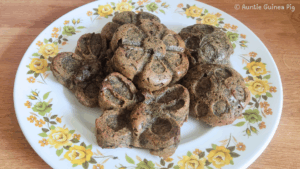 A plate of little cakes in fun shapes. The muffins are a brown-green color. The plate has yellow flowers.